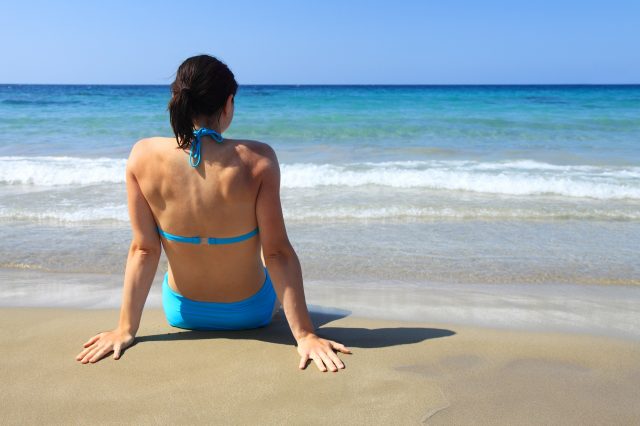 femme assise face à la plage