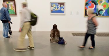 personnes regardant des oeuvres au musée