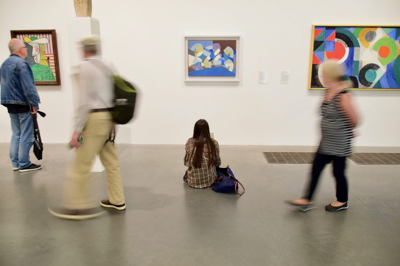 personnes regardant des oeuvres au musée