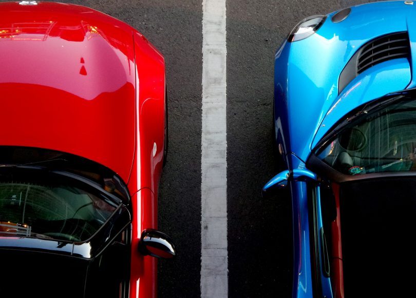 voiture rouge et voiture bleue le long d'une bande blanche