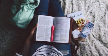 livre ouvert sur les jambes d'une femme dans un lit