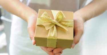 paire de mains tenant un paquet cadeau