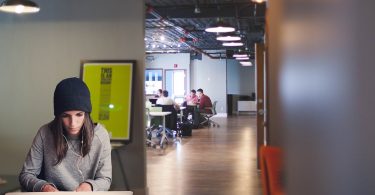 femme travaillant devant un ordinateur dans un bureau ouvert