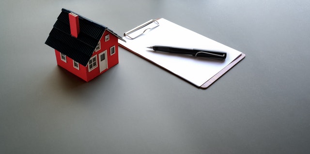 petite maison sur table avec papier et crayon