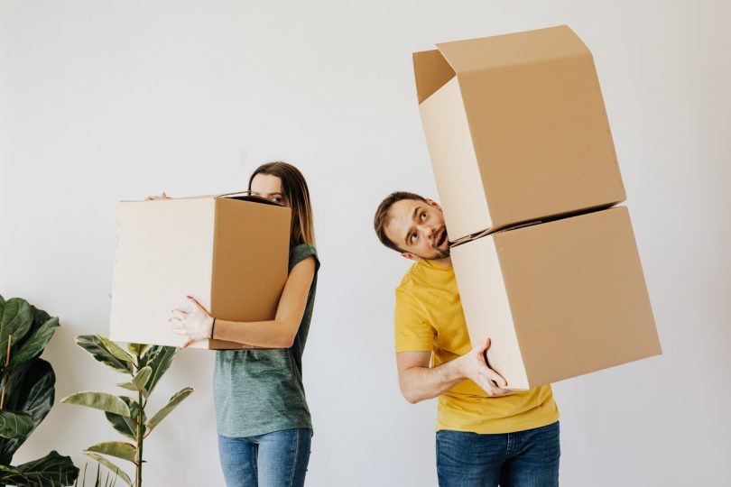couple portant des cartons de déménagement
