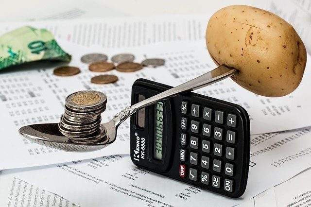 une calculatrice de l'argent et une pomme de terre en équilibre